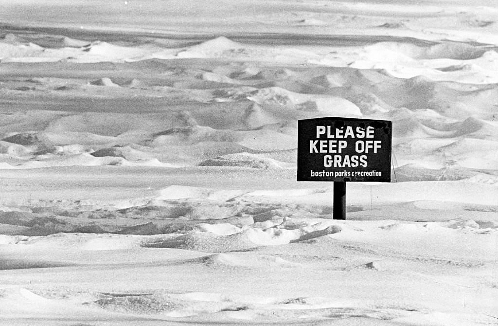A sign in the snow at Boston's Public Garden reads, 'Please keep off the grass', 1974.