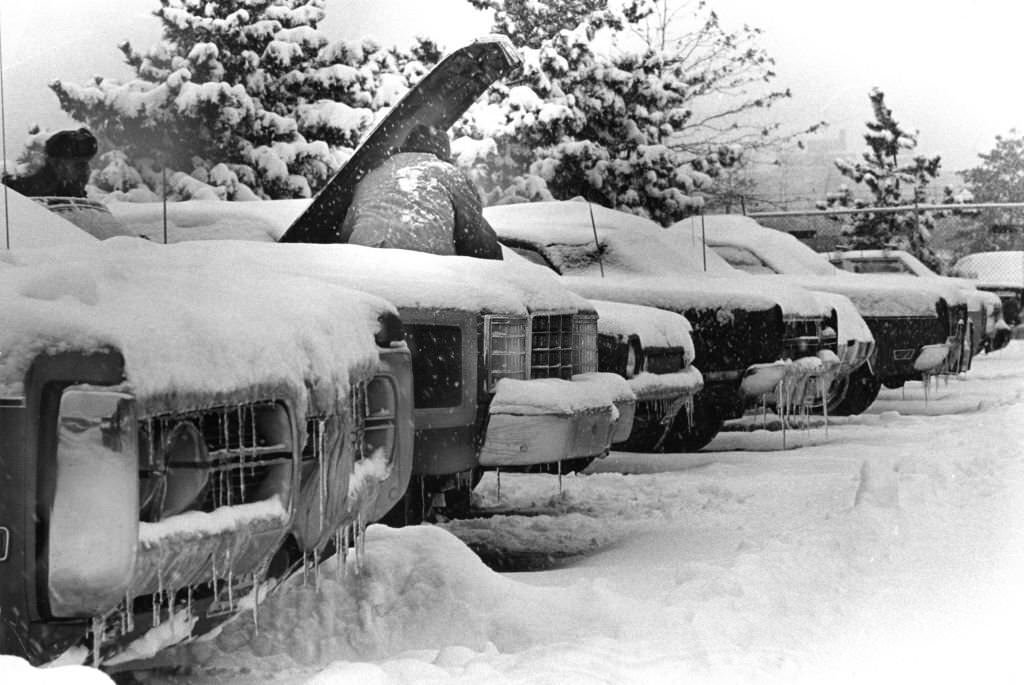 A homeward-bound motorist faces car troubles following snowfall, 1974.