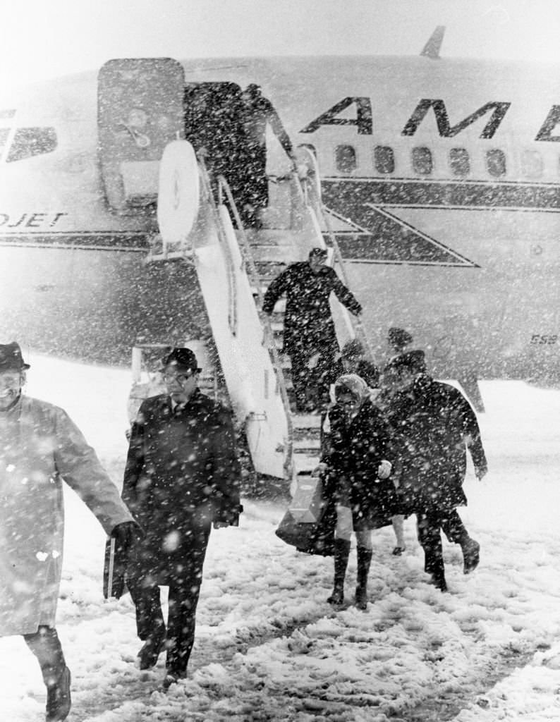 The last load of passengers get off a plane in the snow at Logan International Airport in Boston, 1969.