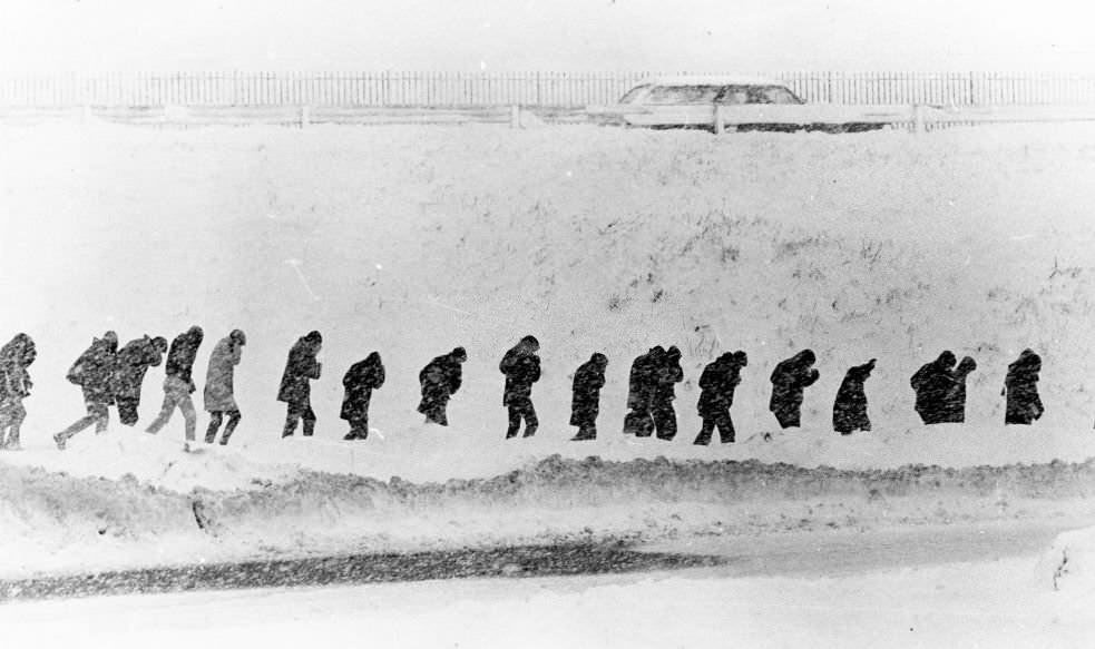 Boston College High School students walk along the base of Columbia Circle in a snow storm in Boston, 1969.