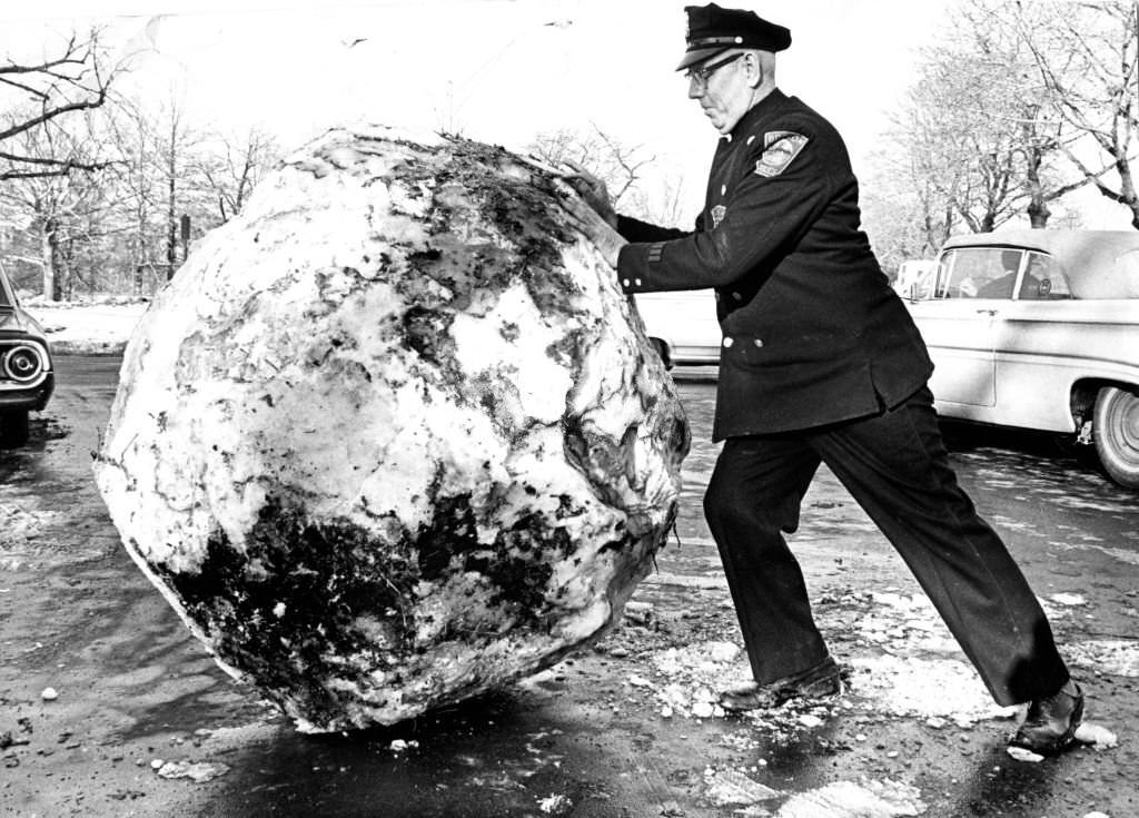 Boston police officer George Floyd pushes a giant snowball out of the way of blocked traffic in the Fenway neighborhood of Boston on Jan. 14, 1966.
