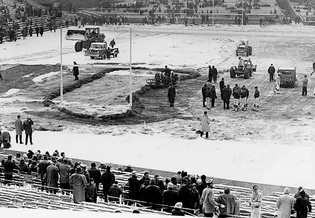 Players and officials checked the field, which was being cleared of snow before the game at Fenway Park.
