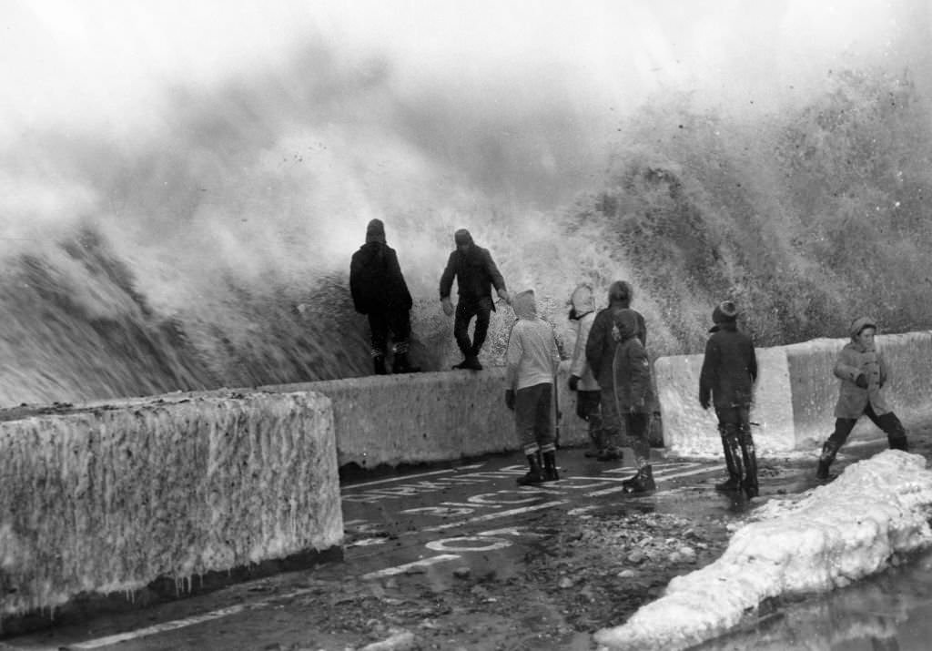 Young residents along the Winthrop, Mass., shore drive play hazardous game with violent waves during a storm, 1961.