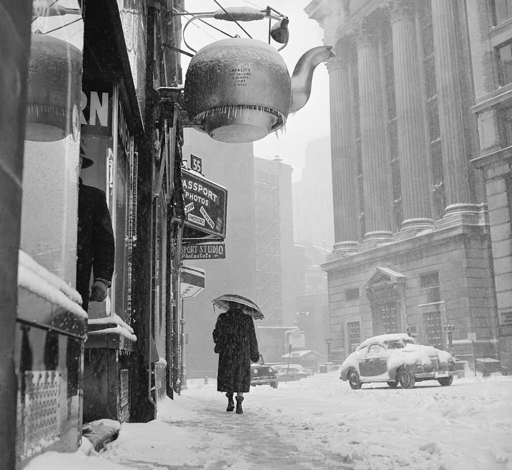 Boston's famous steaming kettle bravely spouts a hot vapor March 24th, while a lone pedestrian bends into the 3rd snow storm to hit the city in a month.