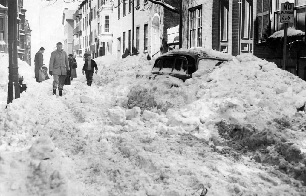 People walk through the snow down the street, 1956.