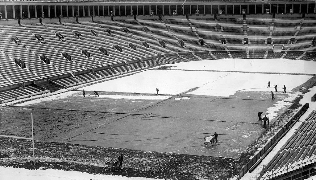 Workmen clear snow away from Harvard Stadium's field at Harvard University in Boston in November 1929, in preparation for a game against Yale University.