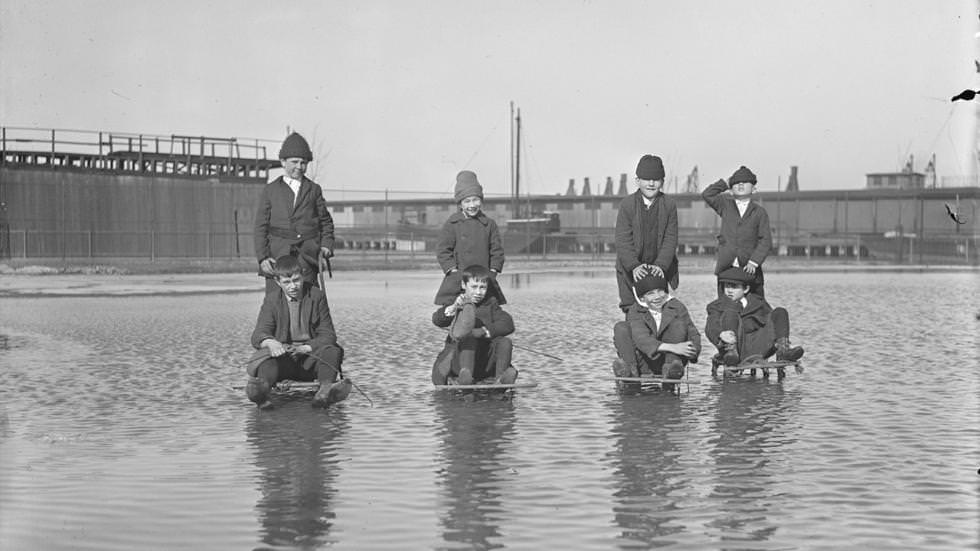 Kids on sleds plough through water to enjoy ice hidden below, 1921