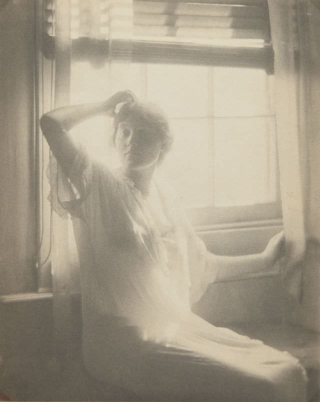 Woman seated in front of window, circa 1910