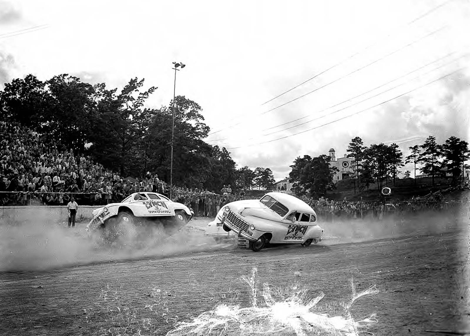 Two Death Dodgers drive over a ramp to go up on two wheels.