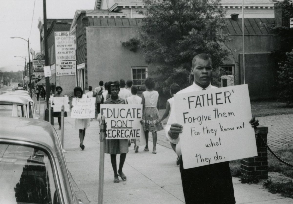 The Rev. Goodwin Douglas, pastor of Beulah AME, with “Father forgive them…” sign.
