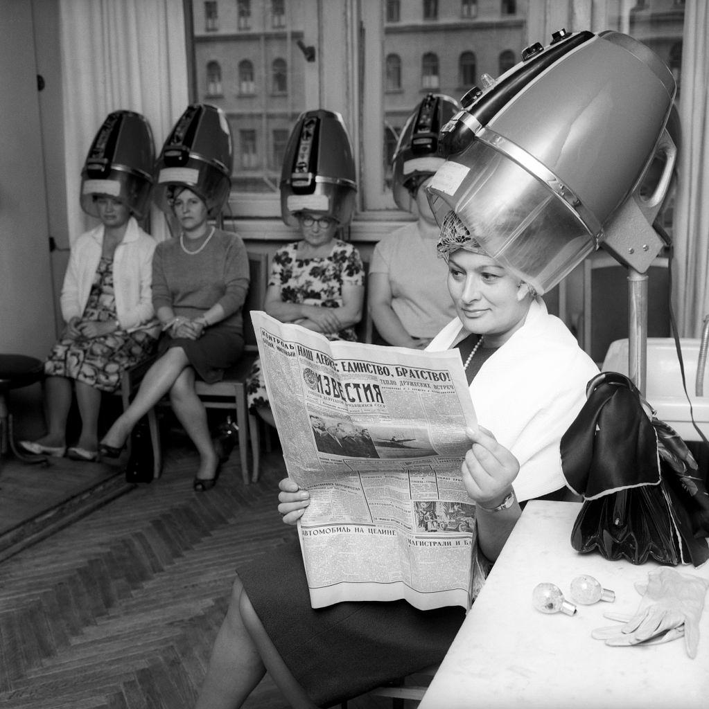 Edda Vincenzi's hair is being arranged before she comes on stage; she is reading a Russian newspaper. Moscow, September 1964.