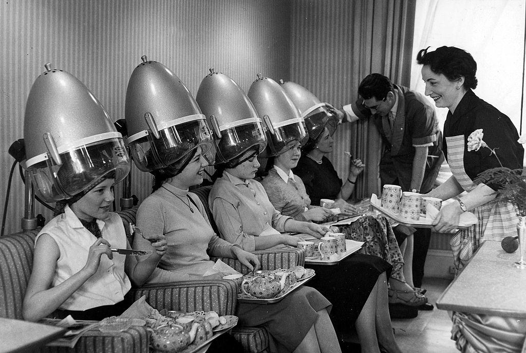 Luncheon is served to ladies under the hairdryers at the hairdressers, 1957