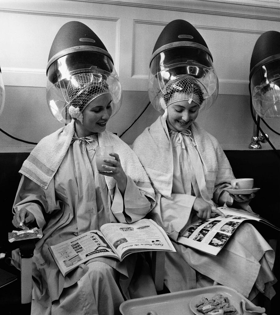 Women relax as they sit under hair dryers at the Valentino & Rita of Knightsbridge beauty salon in London.