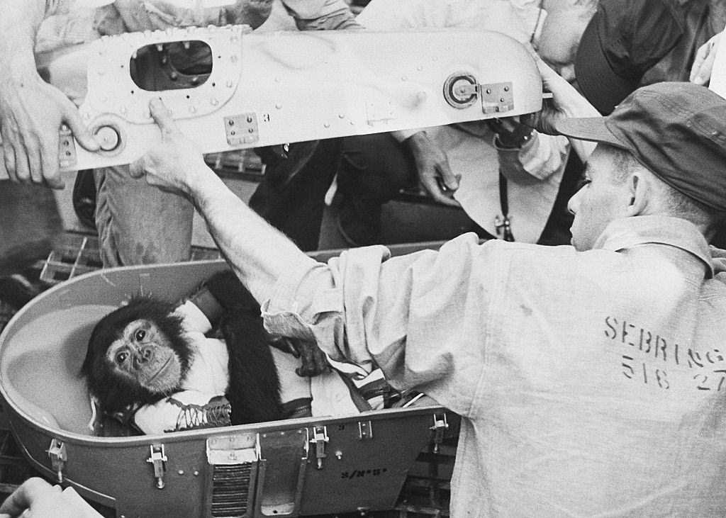 Several men open the space capsule of Ham the Space Chimp after his historic flight on a recovery ship off Cape Canaveral.