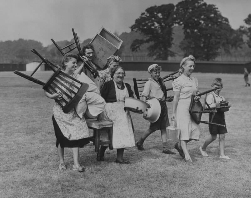 Hop pickers move furniture into their summer quarters at Buston Manor near Maidstone, Kent, 1949.