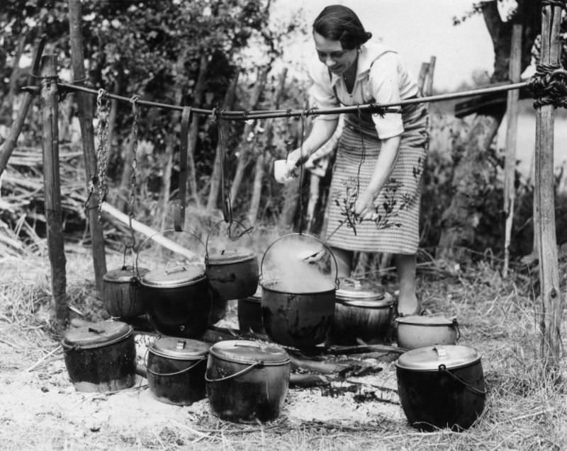 A woman prepares a meal for hop pickers at the Whitbread hop camp in Paddock Wood, Kent, 1937.