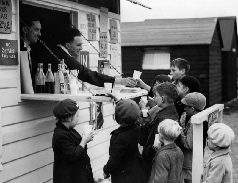 A group of young hop pickers enjoy glasses of milk from a milk bar near the fields in Kent, 1938.