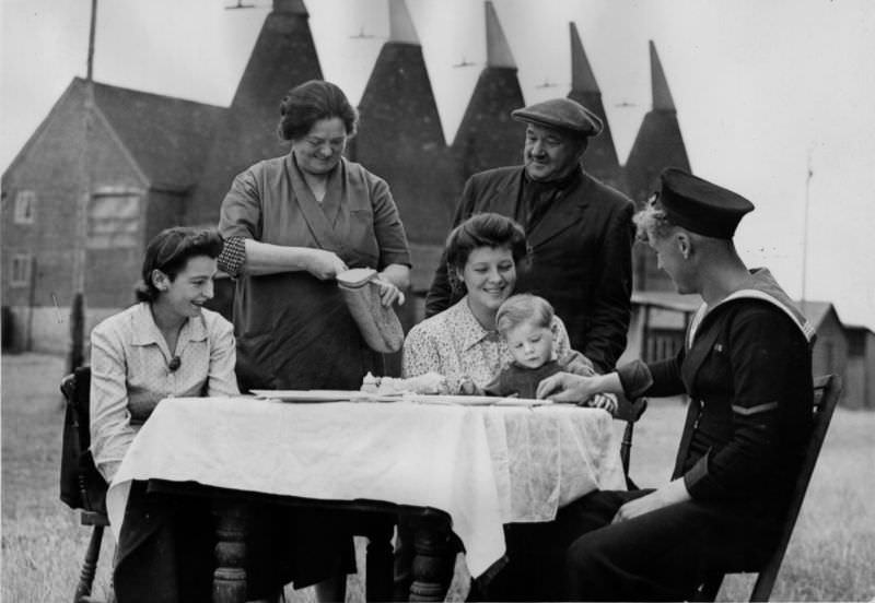 A host serves lunch to a hop picking family in Kent, 1944.