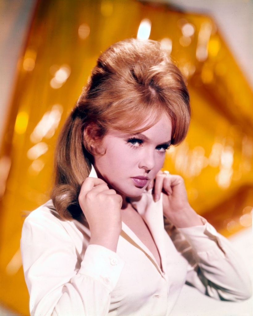 Joey Heatherton poses holding the collar of her white blouse, 1965