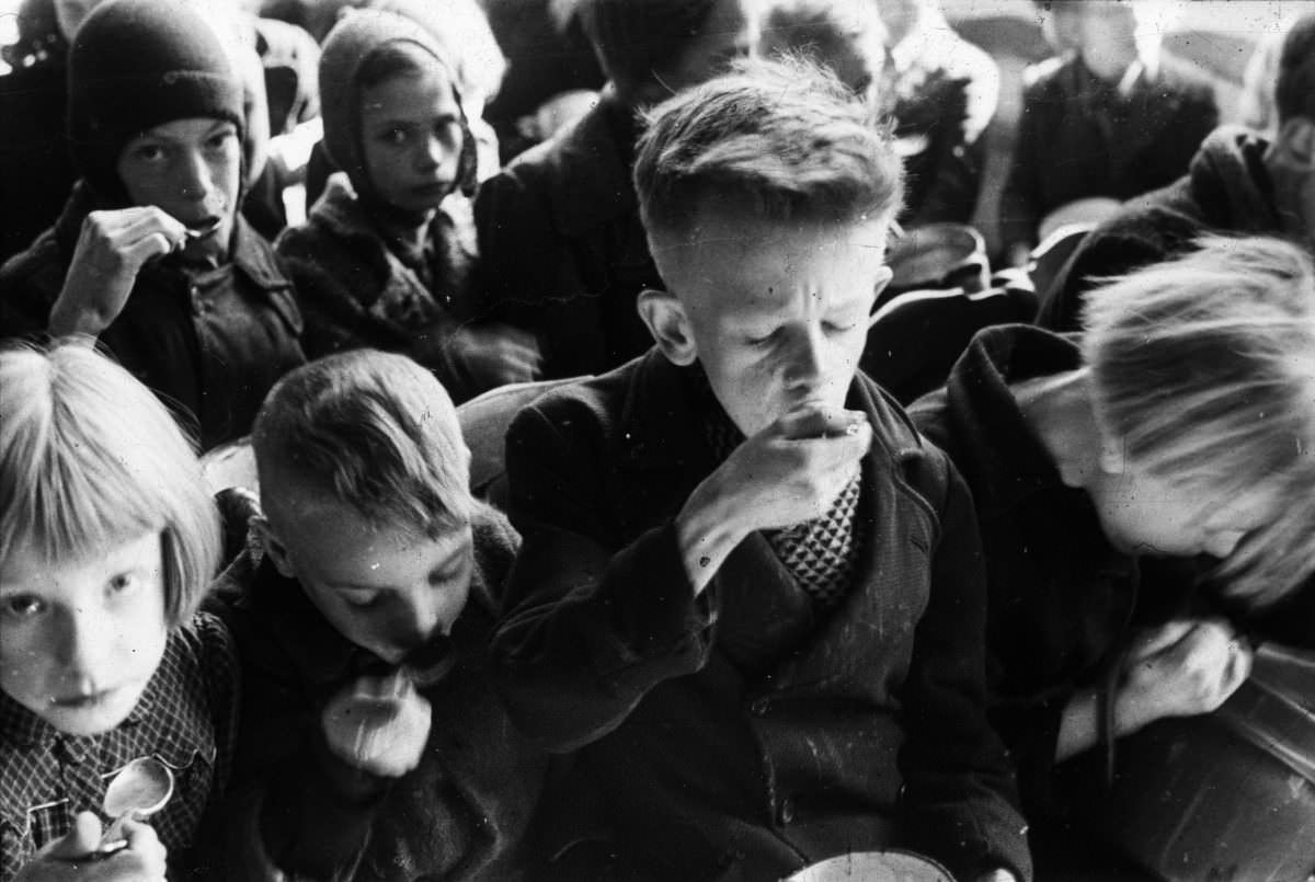 Children eat half a liter of supplementary food, which they received daily during the Hunger Winter from the Inter-Church Office.