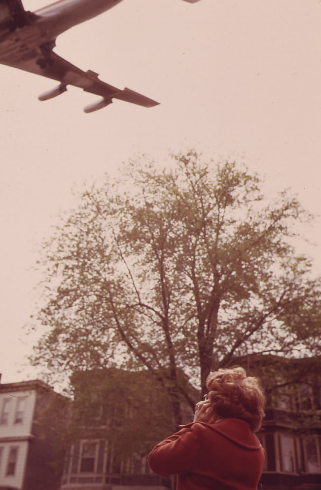 Mary Bruno Holds Her Ears Against Noise of Jet Coming in for a Landing on Runway 15r at Logan Airport.