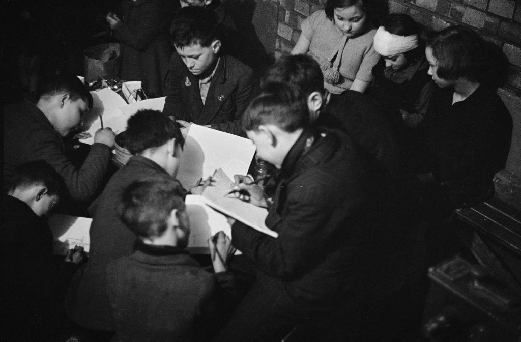 Children drawing in an art class given by London County Council (LCC) teachers at an air raid shelter in Bermondsey, London during the Blitz, March 1941.