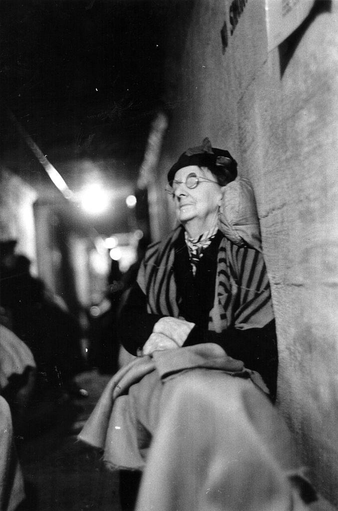 An elderly lady propped up to sleep in an air raid shelter during the Blitz, London, October 1940.