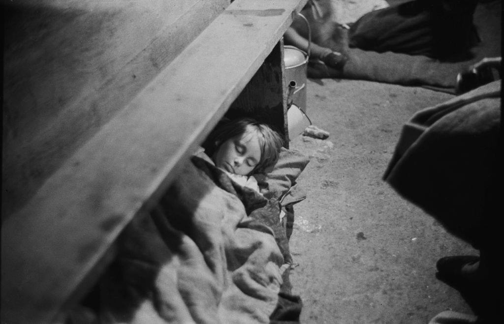 A child sleeping in an air raid shelter during the Blitz, London, October 1940.