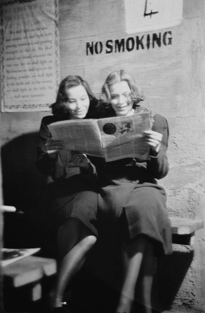 Two young women reading a magazine in an air raid shelter during the Blitz, London, October 1940.