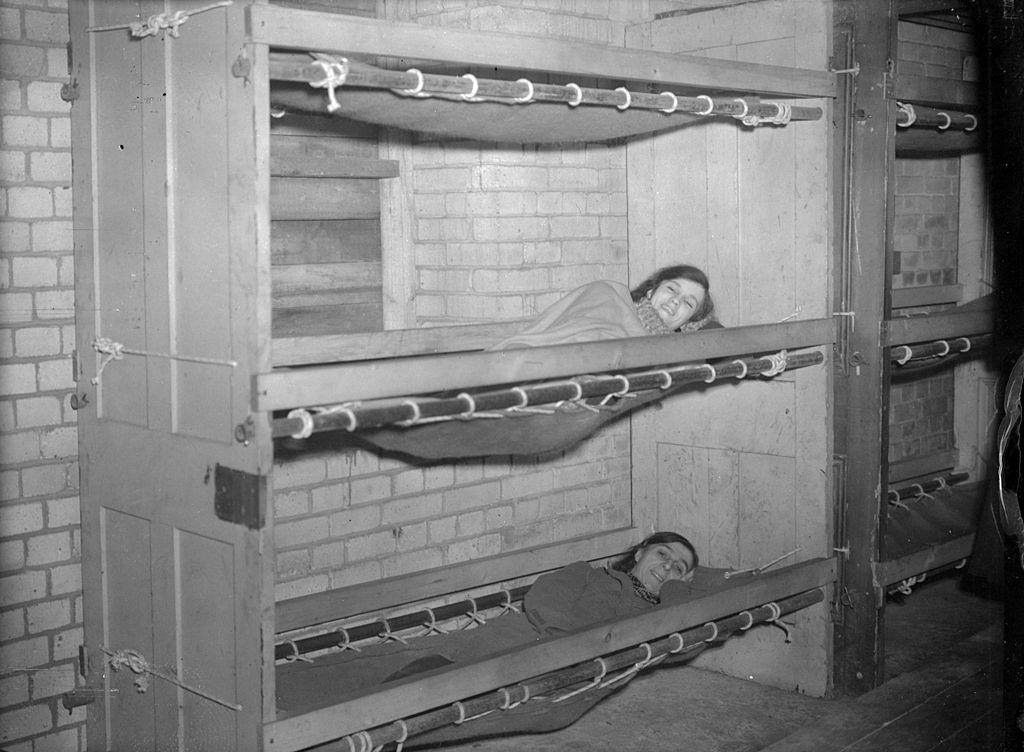 Old doors are used as bed-heads, steel tubing is the framework and canvas the matress for bunk beds in a London shelter during WW II.