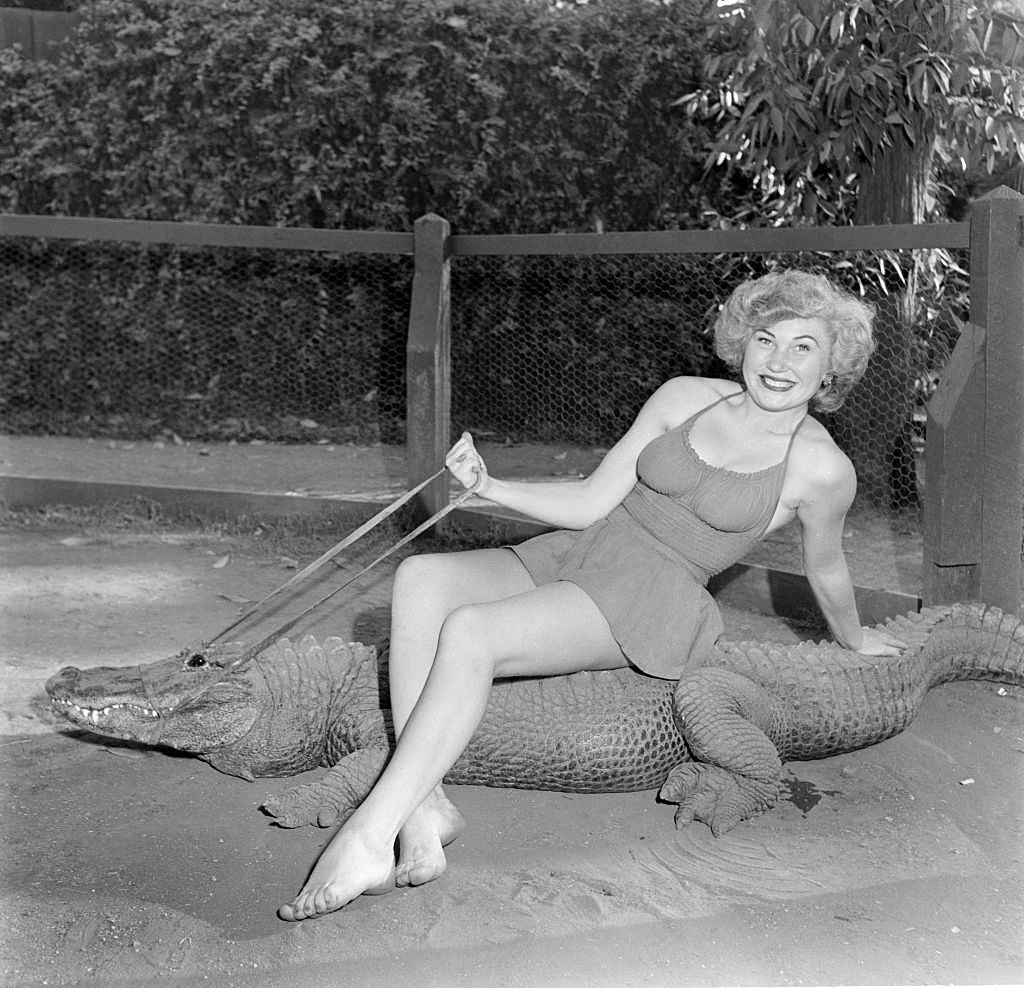 A model poses as she rides an alligator at the Los Angeles Alligator Farm at 3627 Mission Road in the Lincoln Heights area of Los Angeles, California.