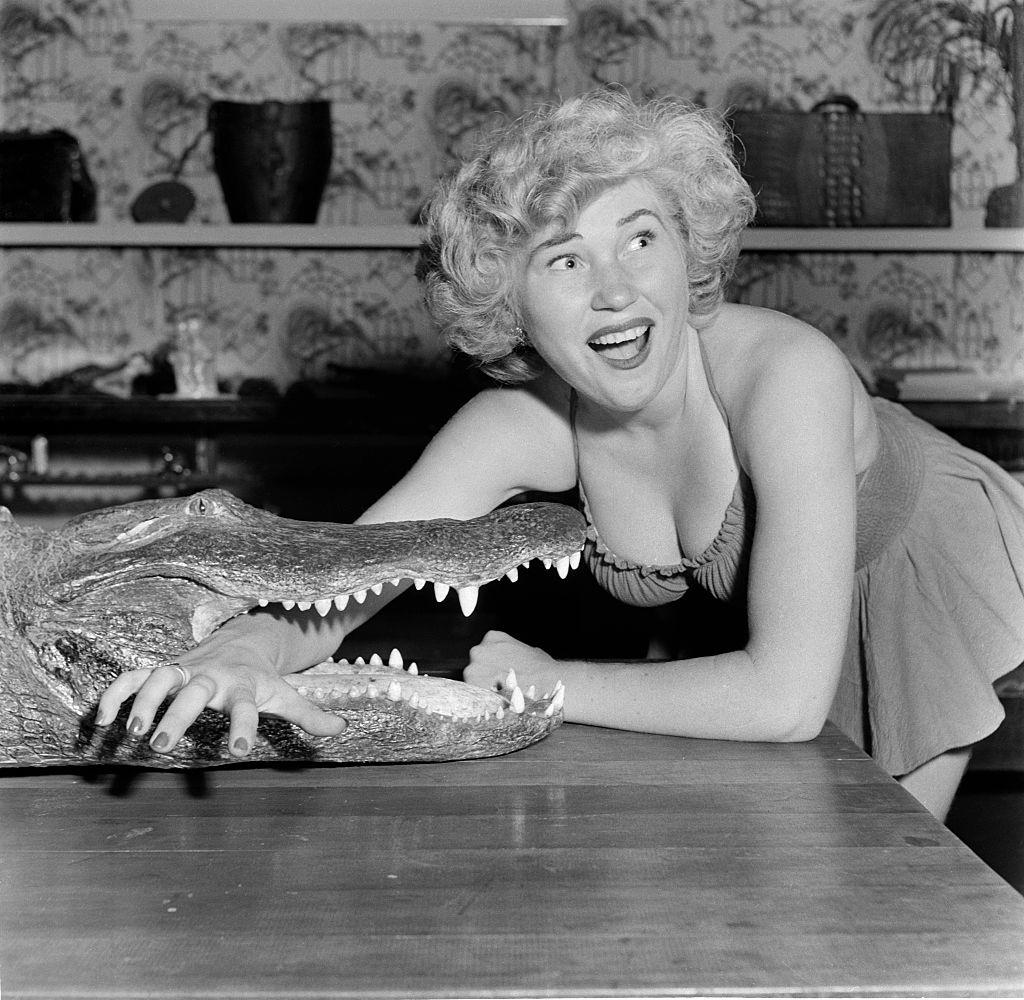 A model poses with an alligator at the Los Angeles Alligator Farm, 1949