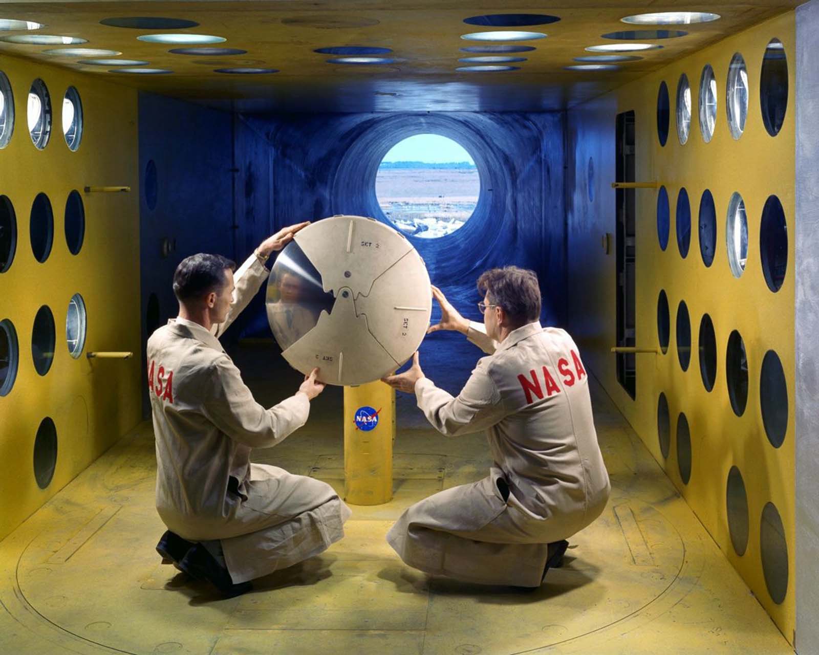 Technicians install a model of an Apollo command module in the 9 x 6-foot Thermal Structures Tunnel for tests of possible heat shield materials, 1962.