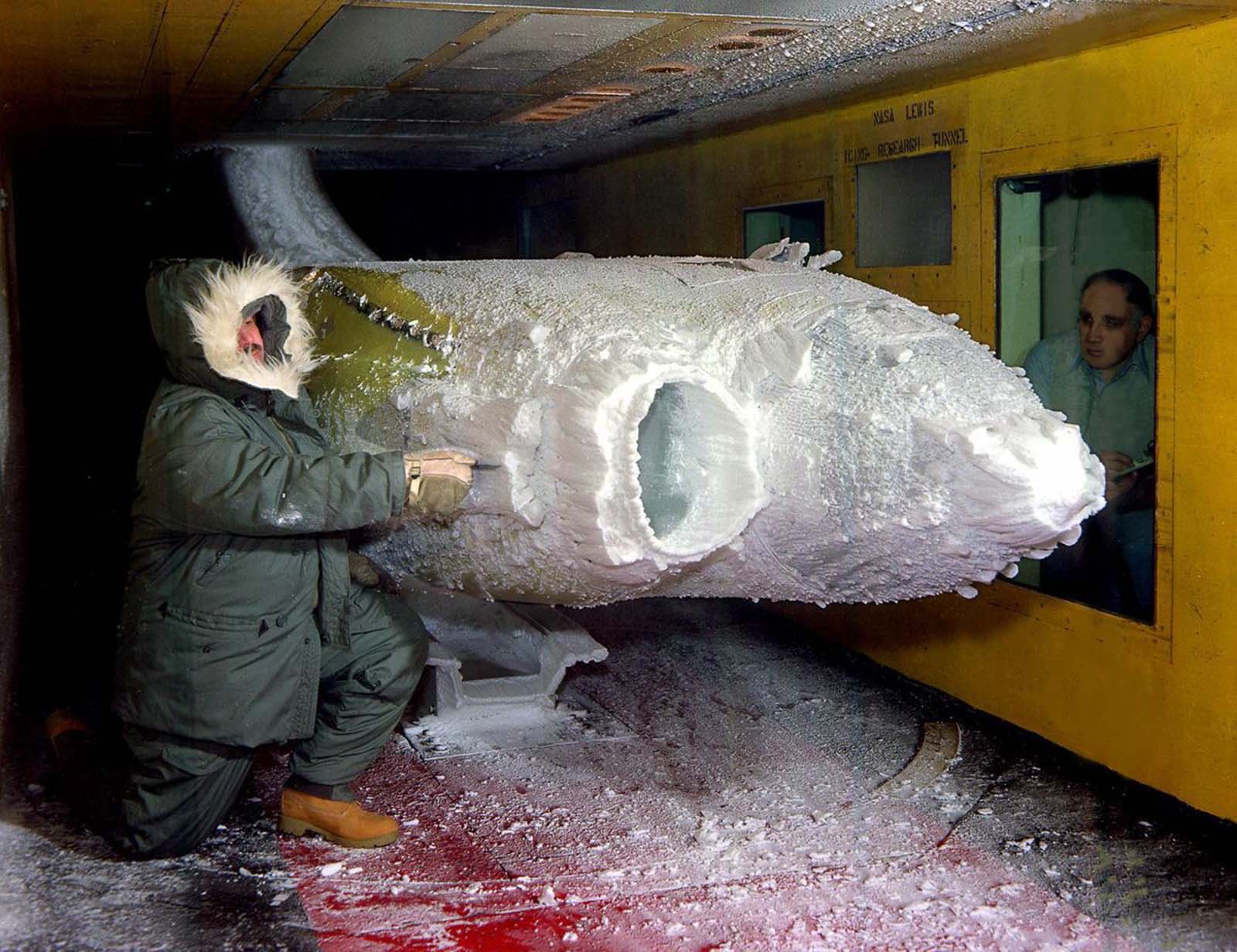 A researcher examines the ice build-up on a turboprop engine nacelle in the Icing Research Tunnel, 1983.