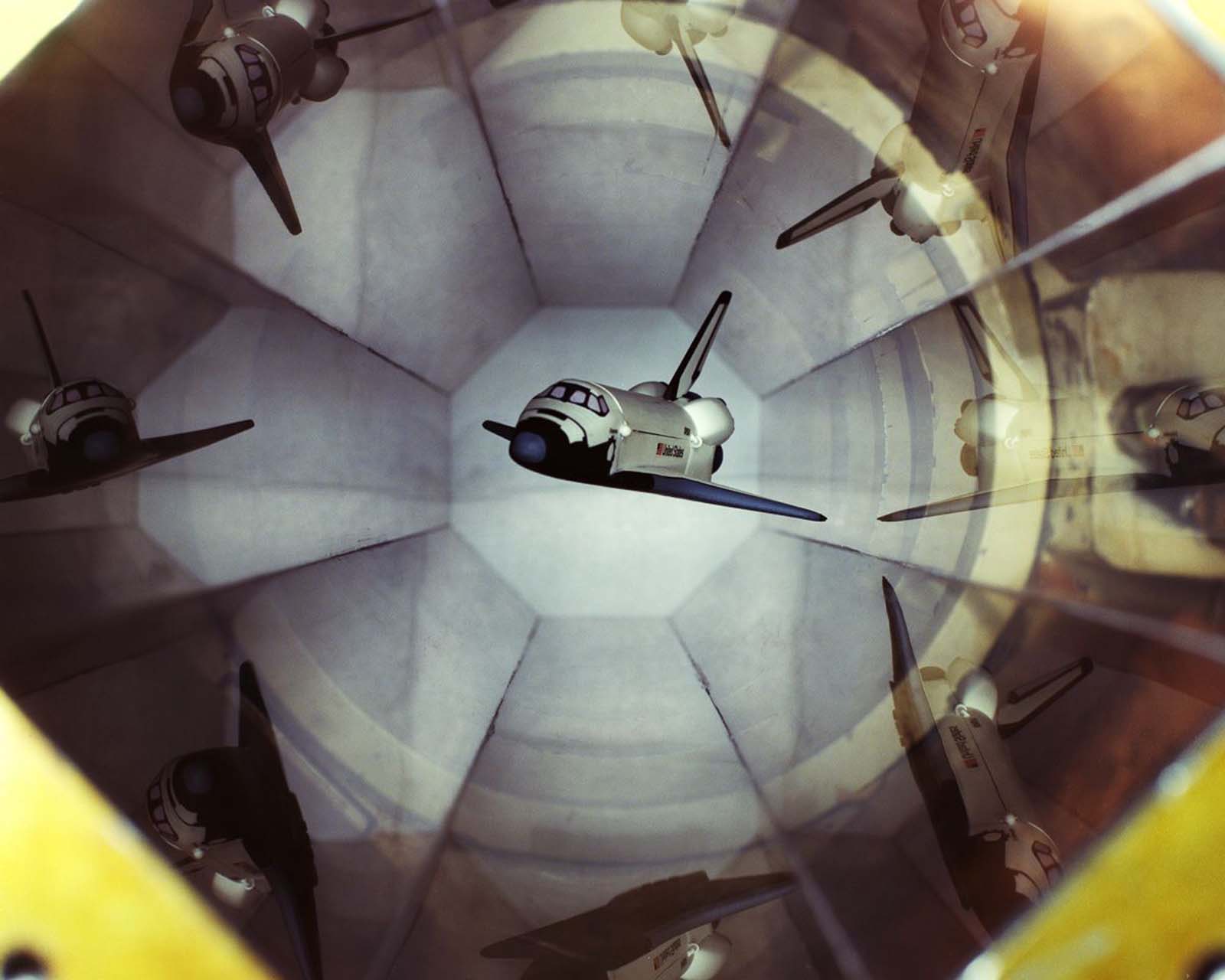 A shuttle model is magnetically suspended in the transparent hexagonal test section of the MIT/NASA Langley 6 inch MSBS.