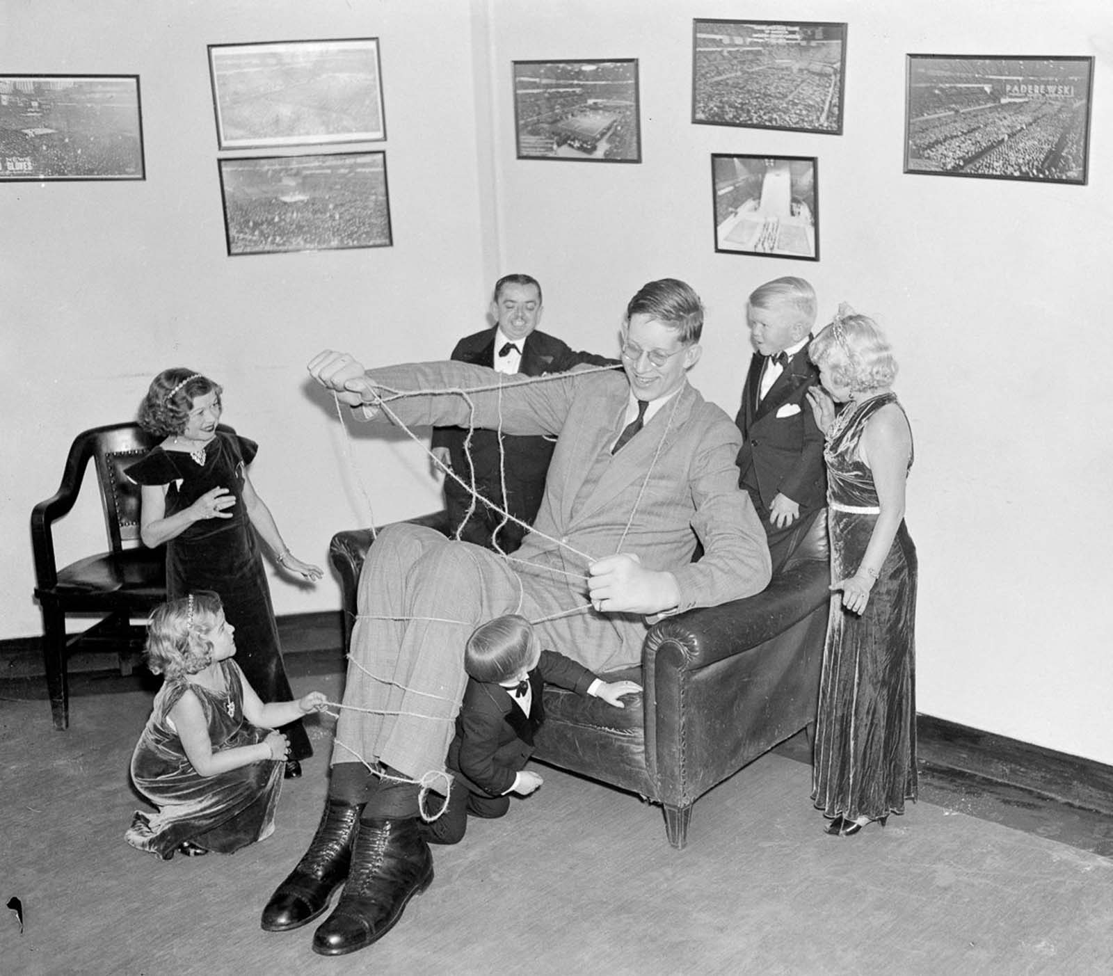 In a nod to Gulliver’s Travels, performers from Ringling Brother’s Circus tie up Wadlow as a means of getting acquainted, 1937.