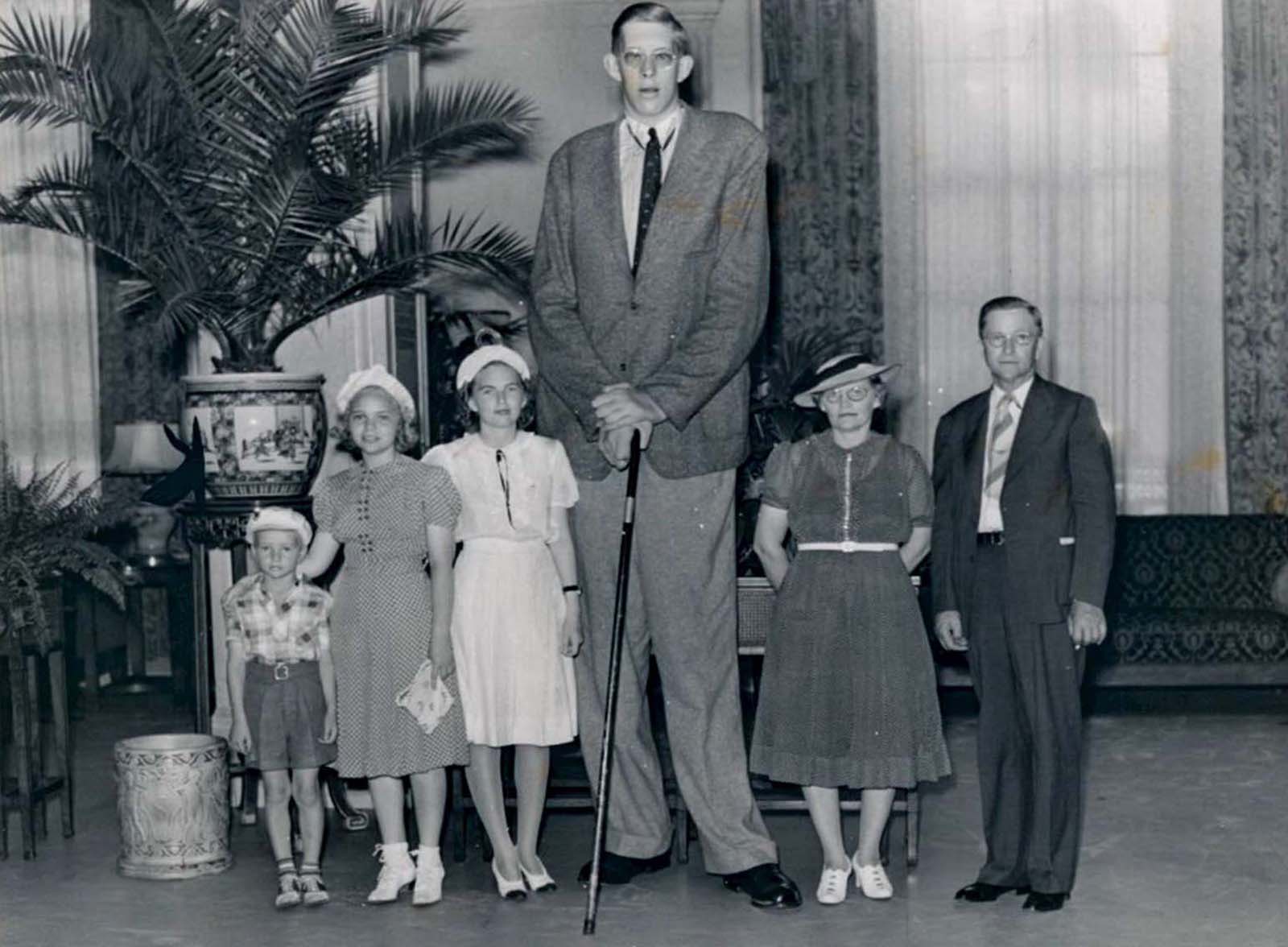The tallest man in the world stands alongside his family, who are all of average height and weight.