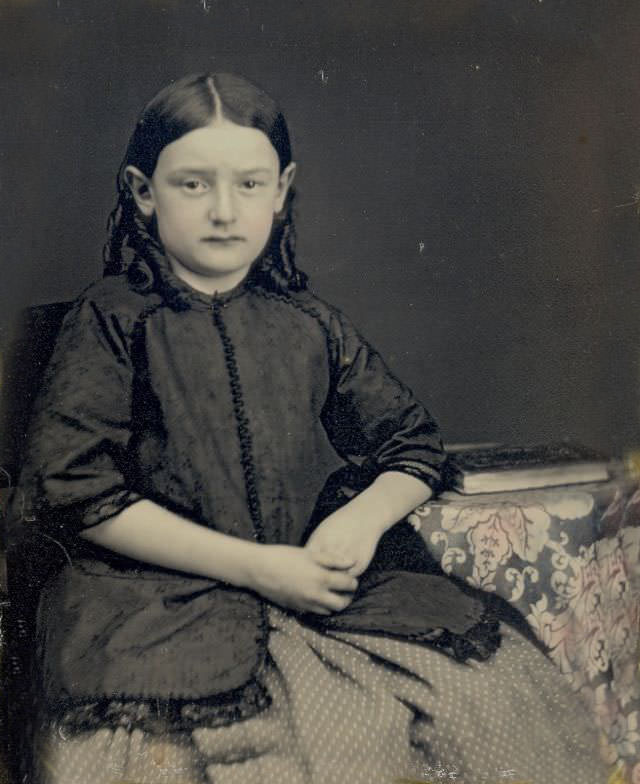 A young school girl posed with her book