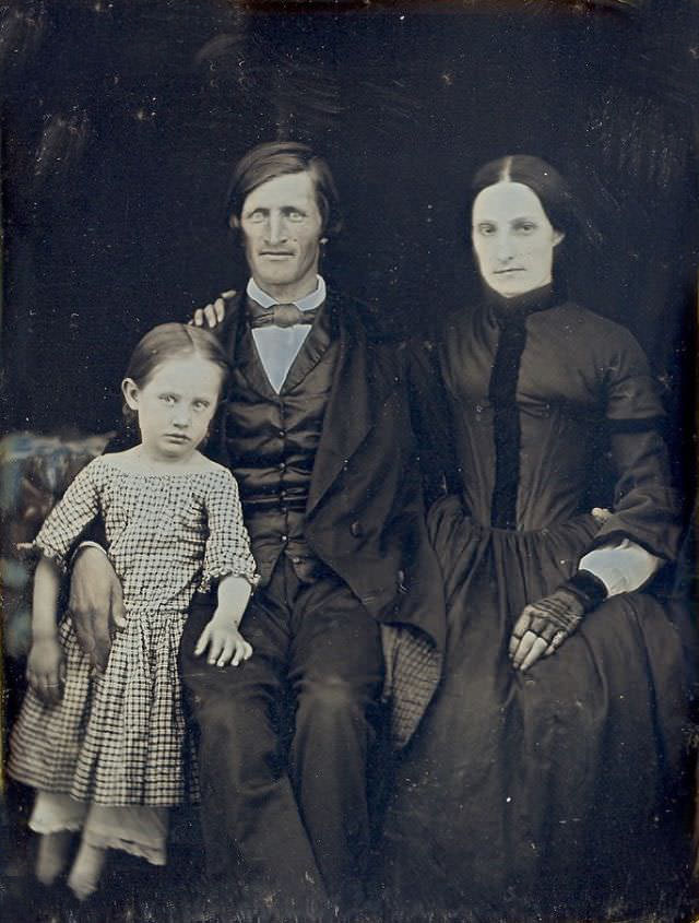 Family photo with little girl leaning on her dad