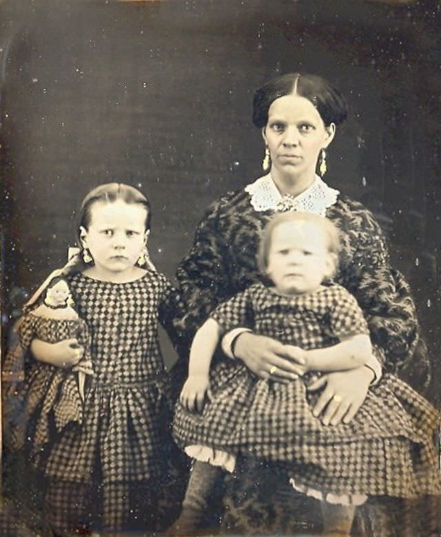 Mom and her two girls in matching dresses including the doll