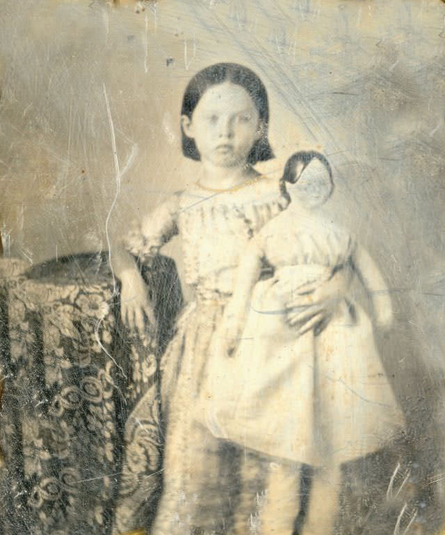 A little girl holding a very large doll