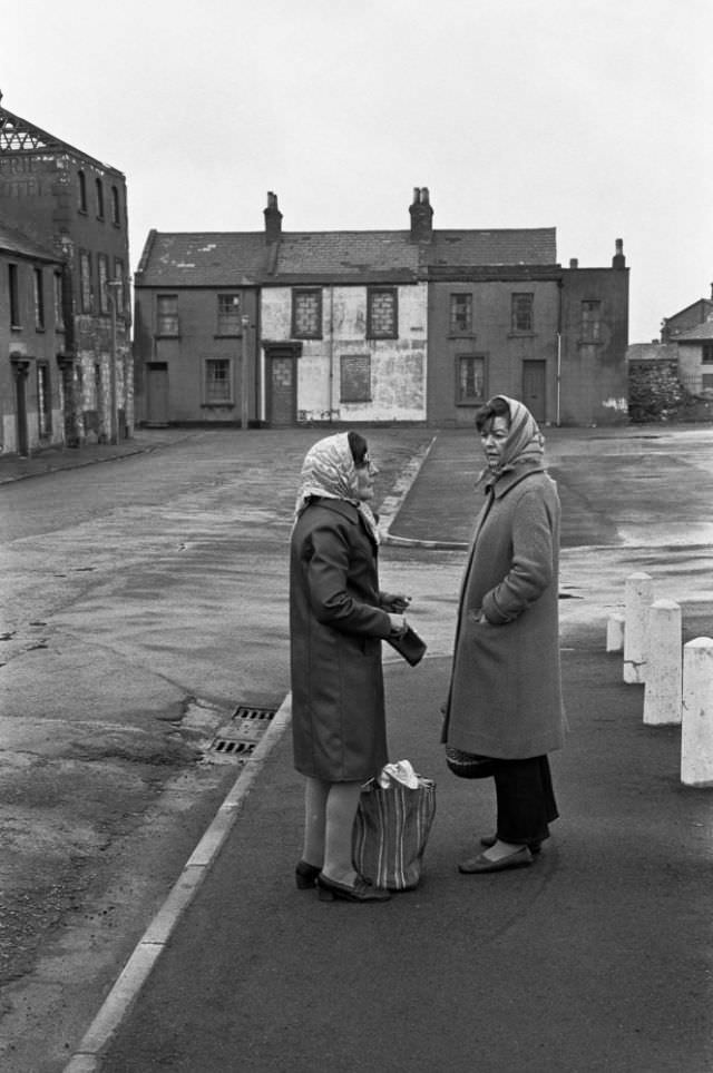 Women chatting in a street of boarded up houses awaiting demolition, Butetown (Tiger Bay), Cardiff