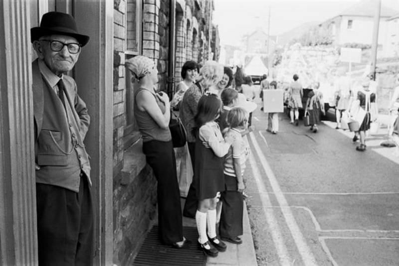 People watch the carnival procession pass in Abertillery