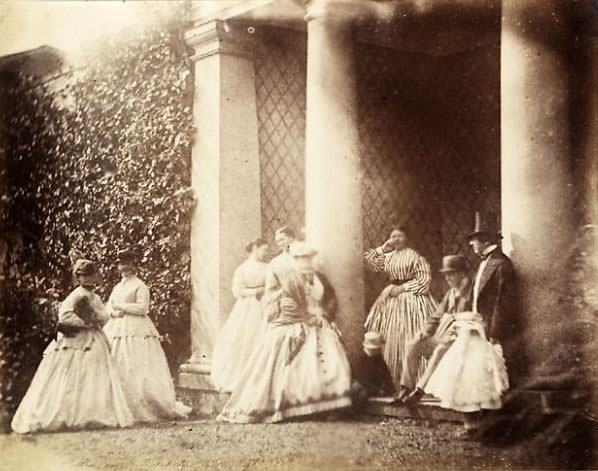 Calvert Richard Jones (on the right), with six women, a man, boy, girl and dog, standing and sitting in a colonaded porchway