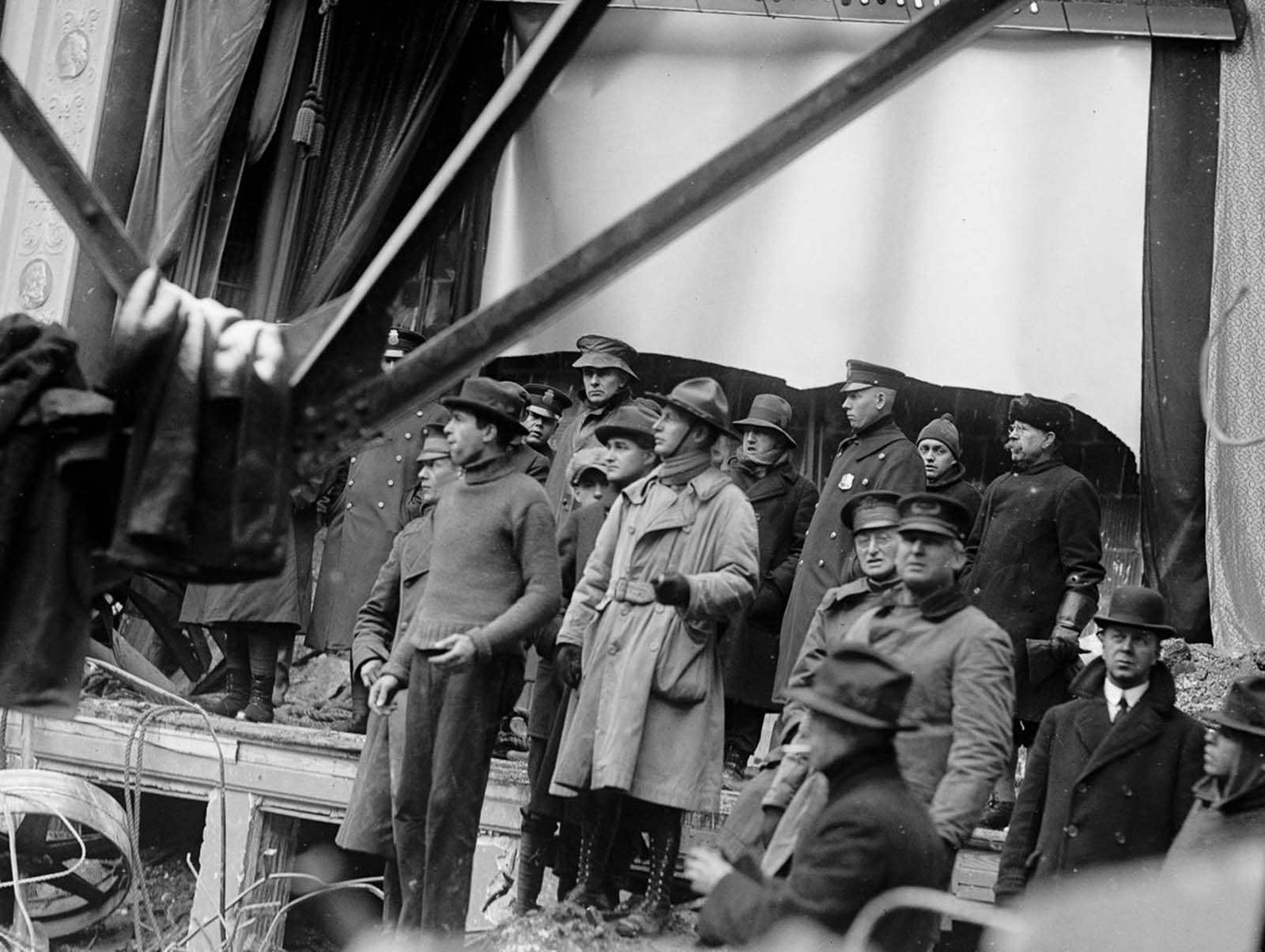 Police, soldiers, and rescue workers examine the ruins of the Knickerbocker Theatre.