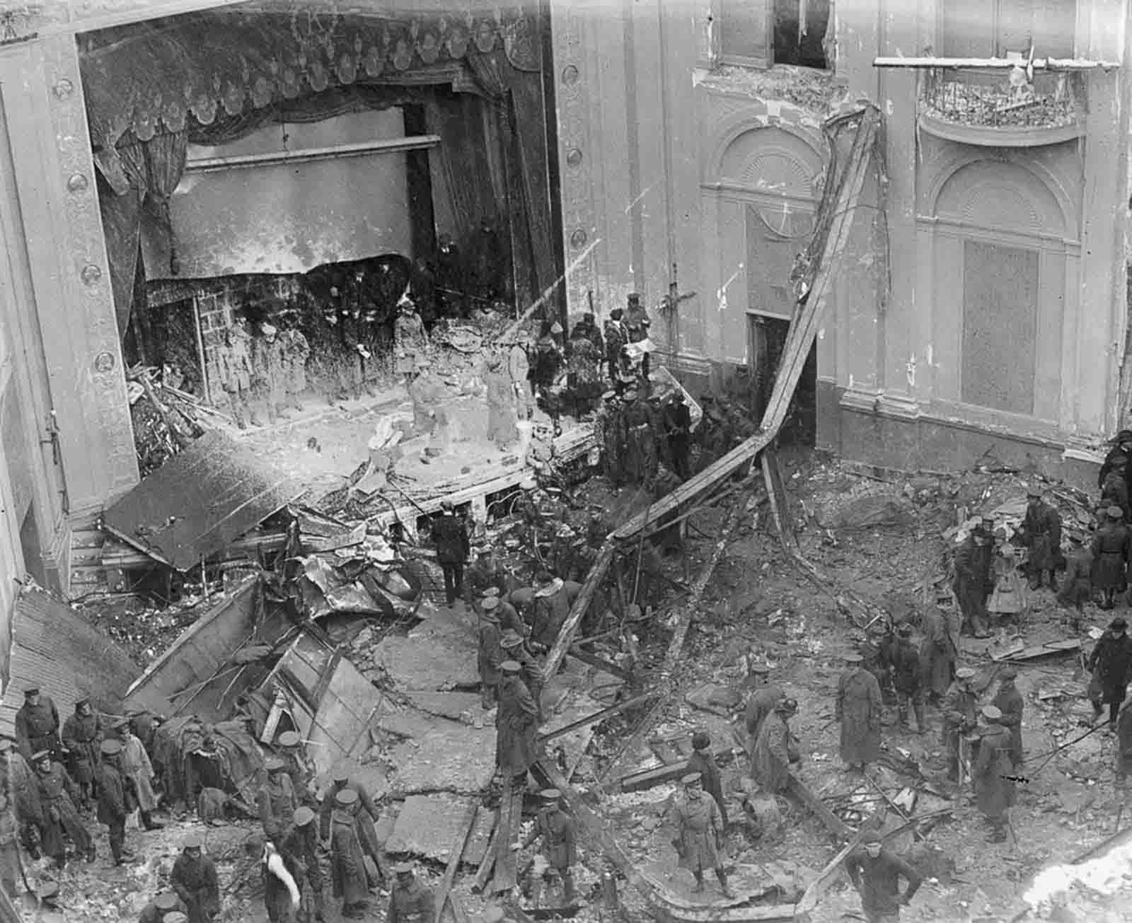 Police, soldiers, and rescue workers examine the ruins of the Knickerbocker Theatre.