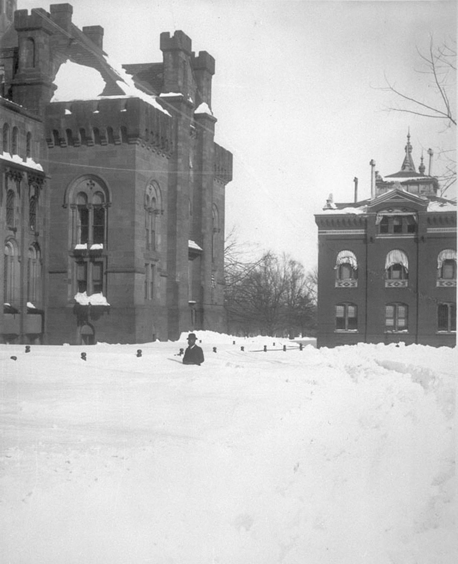 A man walks through deep snow drifts near the Smithsonian Institution.