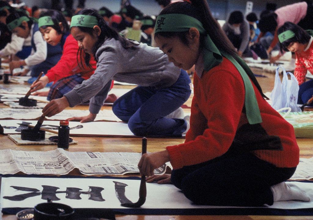 School children show off their calligraphies 1/5 in a New Year's brush-writing contest attended by nearly 5,000 kindergarten tots to grown-up adults at Tokyo's Budokan Hall.