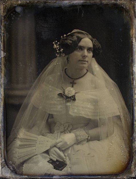 An Victorian bride looking radiantly lovely in her elegant, feminine white dress, ca. 1850s