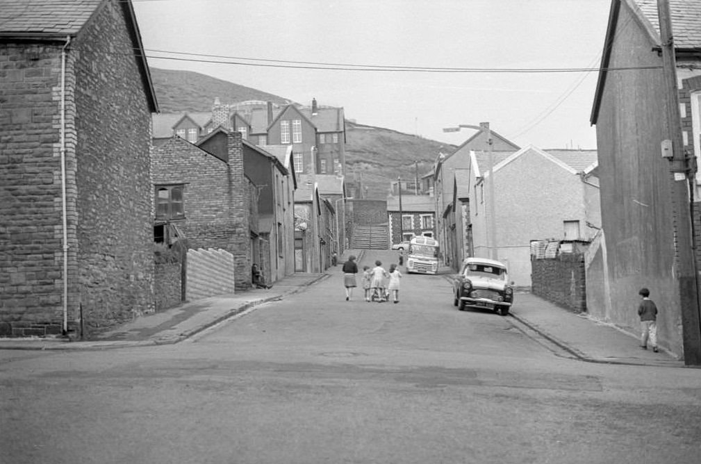 A mother and her three children walk along a near empty street in the mining town of Tonypandy, Wales, United Kingdom, 1966.